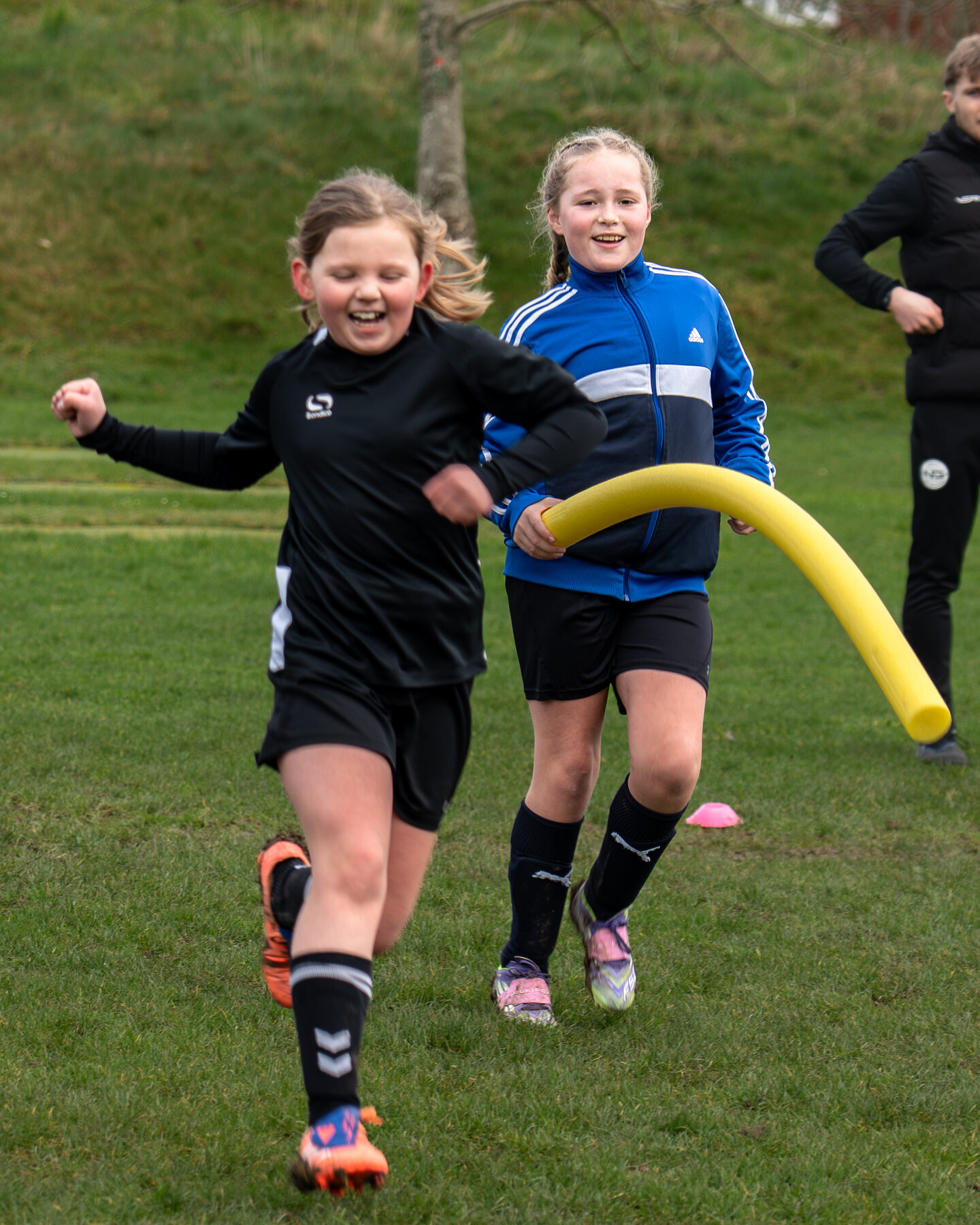 Two girls competing for the ball at an NGFC session